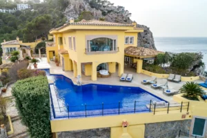 Blick von vorne auf die Villa mit Pool im Vordergrund.