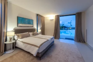 Schlafzimmer mit Blick auf den Pool am Abend